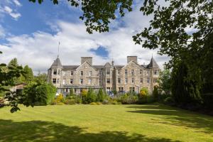 een groot gebouw met een gazon ervoor bij The Pitlochry Hydro Hotel in Pitlochry