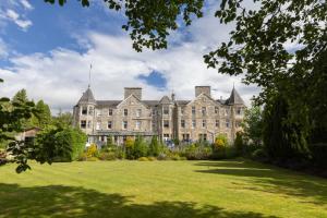 a large building with a lawn in front of it at The Pitlochry Hydro Hotel in Pitlochry