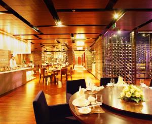 a restaurant with tables and chairs and a wine cellar at Beijing New Century Hotel in Beijing