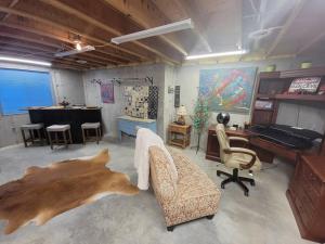 a living room with a desk and a couch and a table at Among the Aspens Family Cottage in Bozeman