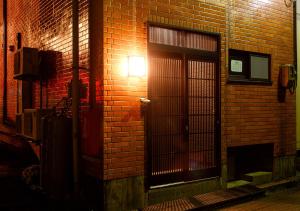 a brick building with a door with a light on it at 金澤の宿 桜橋 in Kanazawa