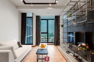 a living room with a white couch and a tv at EXPRESSIONZ KLCC BY G Suites in Kuala Lumpur