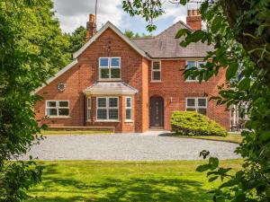 a brick house with a driveway in front of it at Routhorpe House in Bainton