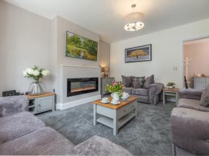 a living room with two couches and a fireplace at Routhorpe House in Bainton