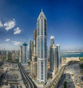 een groot hoog gebouw in een stad met gebouwen bij HIGHRISE APARTMENT ON THE 74TH FLOOR in Dubai
