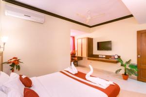 Una habitación de hotel con una cama con cisnes. en Octave Plaza Hotel en Bangalore