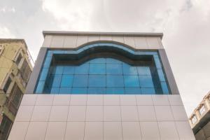 a tall glass building with blue windows at Octave Plaza Hotel in Bangalore