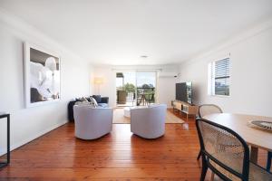 een woonkamer met een tafel en stoelen bij Harbour view huge 2 bedroom entire residence. in Sydney