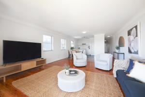 a living room with a tv and a couch and chairs at Harbour view huge 2 bedroom entire residence. in Sydney