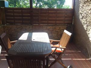 - une table de pique-nique et des chaises sur la terrasse dans l'établissement Maison chaleureuse, à Montignac