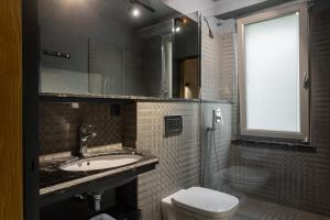 a bathroom with a sink and a toilet and a window at Plai Hotel in Chişinău