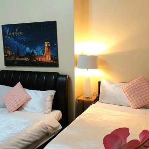 a bedroom with two beds and a painting on the wall at Gabriel Guesthouse in Rhyl