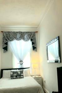 a bedroom with a bed and a window at Gabriel Guesthouse in Rhyl