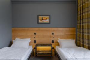 a bedroom with two beds and a table between them at Plai Hotel in Chişinău
