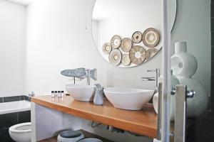 ein Badezimmer mit zwei Waschbecken auf einer Holztheke mit einem Spiegel in der Unterkunft Abalone Hotel & Villa's in Paternoster