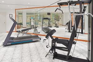 a gym with several tread machines and a mirror at Hipotels Sherry Park in Jerez de la Frontera