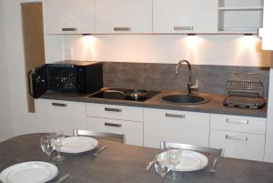a kitchen with a table with two plates and a sink at myappartepinalF1 in Épinal
