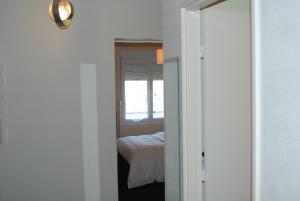a room with a bedroom with a bed and a window at myappartepinalF1 in Épinal +3 photos