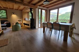 - un salon avec une table, des chaises et une grande fenêtre dans l'établissement Chalet l'ecrin - 6 pers with panoramic view of the Meije, à La Grave