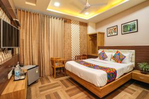 una camera d'albergo con letto e TV di Royal GM Plaza a Jaipur