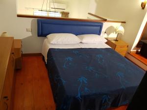 サン・ユーフェミア・ラメツィアにあるModern Apt REVENTINO - Le Lincelle, Lameziaのベッドルーム1室(青い掛け布団付きのベッド1台付)