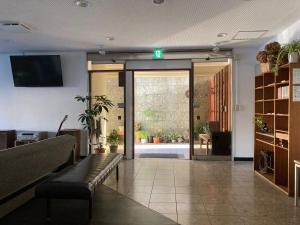 a lobby with a waiting room with a exit sign at J-Hoppers Beppu Guesthouse ジェイホッパーズ別府ゲストハウス in Beppu