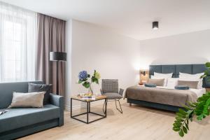 a bedroom with a bed and a couch and a table at Hotel Jazz Market Square Wroclaw in Wrocław