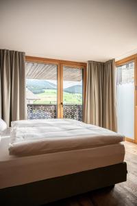 a bedroom with a bed and a large window at Mountain Lodge Margit in Maranza