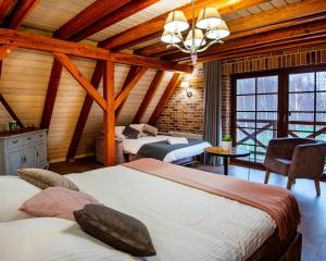 1 dormitorio con 2 camas en una habitación con techos de madera en Helenówka AGRO & SPA, en Komorów