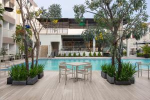 a patio with a table and chairs next to a pool at Sahid Raya Hotel & Convention Yogyakarta in Yogyakarta