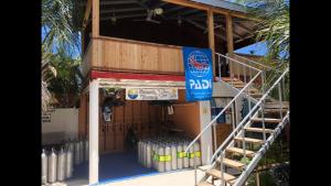 a gas station with a staircase and a blue sign at Shamar Guesthouse & Dive in Maamigili