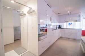 - une cuisine blanche avec des armoires et des appareils blancs dans l'établissement Rothornblick 04 by Arosa Holiday, à Arosa