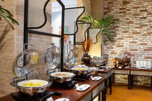 a buffet line with bowls of food in a restaurant at Sahid Raya Hotel & Convention Yogyakarta in Yogyakarta