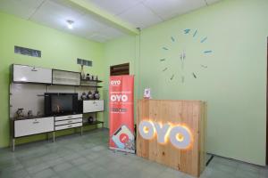 Zimmer mit großer Uhr an der Wand in der Unterkunft Super OYO 1046 Omah Pathok in Yogyakarta
