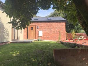 a brick building with a door in a yard at Delightful detached Cottage in Village Centre in Plymtree