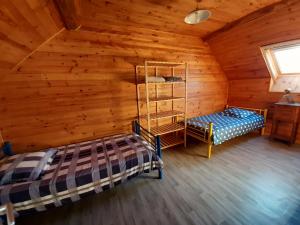 a bedroom in a log cabin with a bed and a shelf at Gite les Courtaillards in Couches