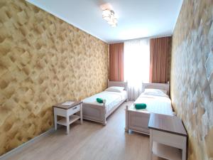 a room with two beds and a table and a window at Apartment on Internacionalnaya 34 in Bobruisk