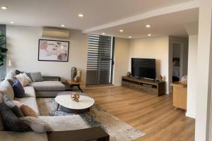 a living room with a couch and a tv at Crows Nest - Executive Penthouse - 3 Bedroom- 5km to City in Sydney