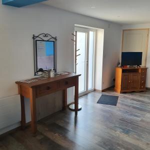 a room with a desk with a mirror and a television at gite de l'ornain in Fains-les-Sources