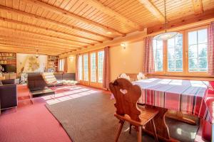 een grote woonkamer met een tafel en een bank bij Chalet Soldanella by Arosa Holiday in Arosa