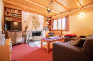 a living room with a couch and a fireplace at Chalet Soldanella by Arosa Holiday in Arosa