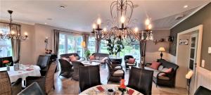 a living room filled with furniture and a chandelier at Hotel Eifelland in Butgenbach