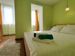 1 dormitorio verde con 1 cama con 2 toallas en Apartament on Sovetskaya 135 en Bobruisk