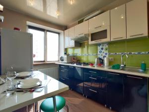 a kitchen with blue cabinets and a white counter top at Apartament on Sovetskaya 135 in Bobruisk