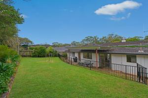 a house with a fence in a yard at 35 Calwalla Crescent Port Macquarie in Port Macquarie