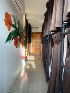 a hallway with rows of bunk beds with flowers on the wall at Kommons by Kamino in Boracay