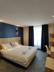 Un dormitorio con una gran cama blanca y una ventana en Hotel Modern Est, en París