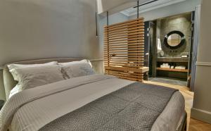 una camera con un grande letto e uno specchio di Nikiou Suites Luxury Residence ad Atene