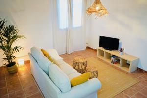 ein Wohnzimmer mit einem Sofa und einem TV in der Unterkunft Siempre Feliz La Casita Los Molinos in Villaverde