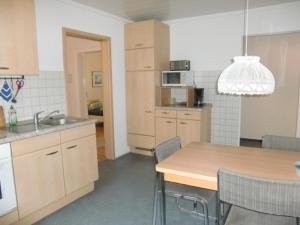 a kitchen with a wooden table and a kitchen with a sink at Ferienwohnung Ilse und Eberhard Tröps in Siegen